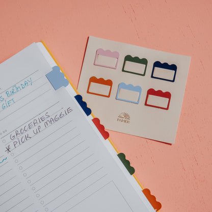 Papier Metal Index Tabs, Multicolor Cloud, with tab dividers on a peach surface.