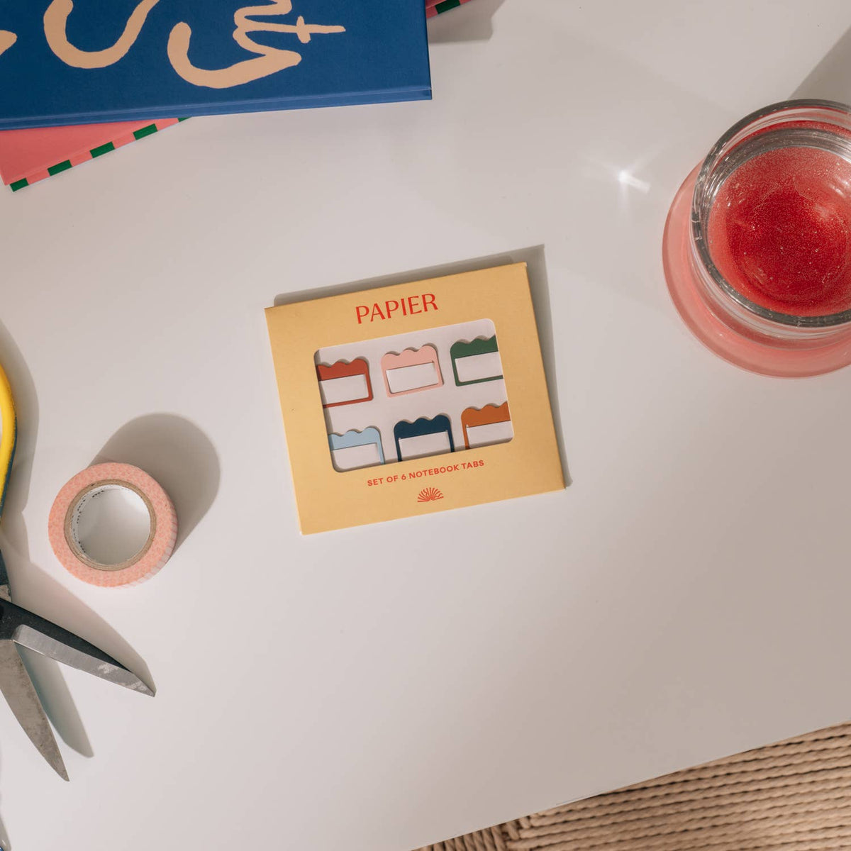 Papier Metal Index Tabs, Multicolor - Cloud, rest on a desk with scissors, tape, and a candle.