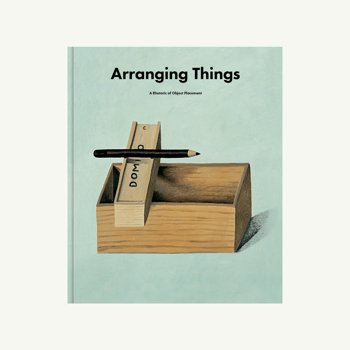 Book cover: Arranging Things by Apartamento—object placement with pencil and labeled sticks on box.