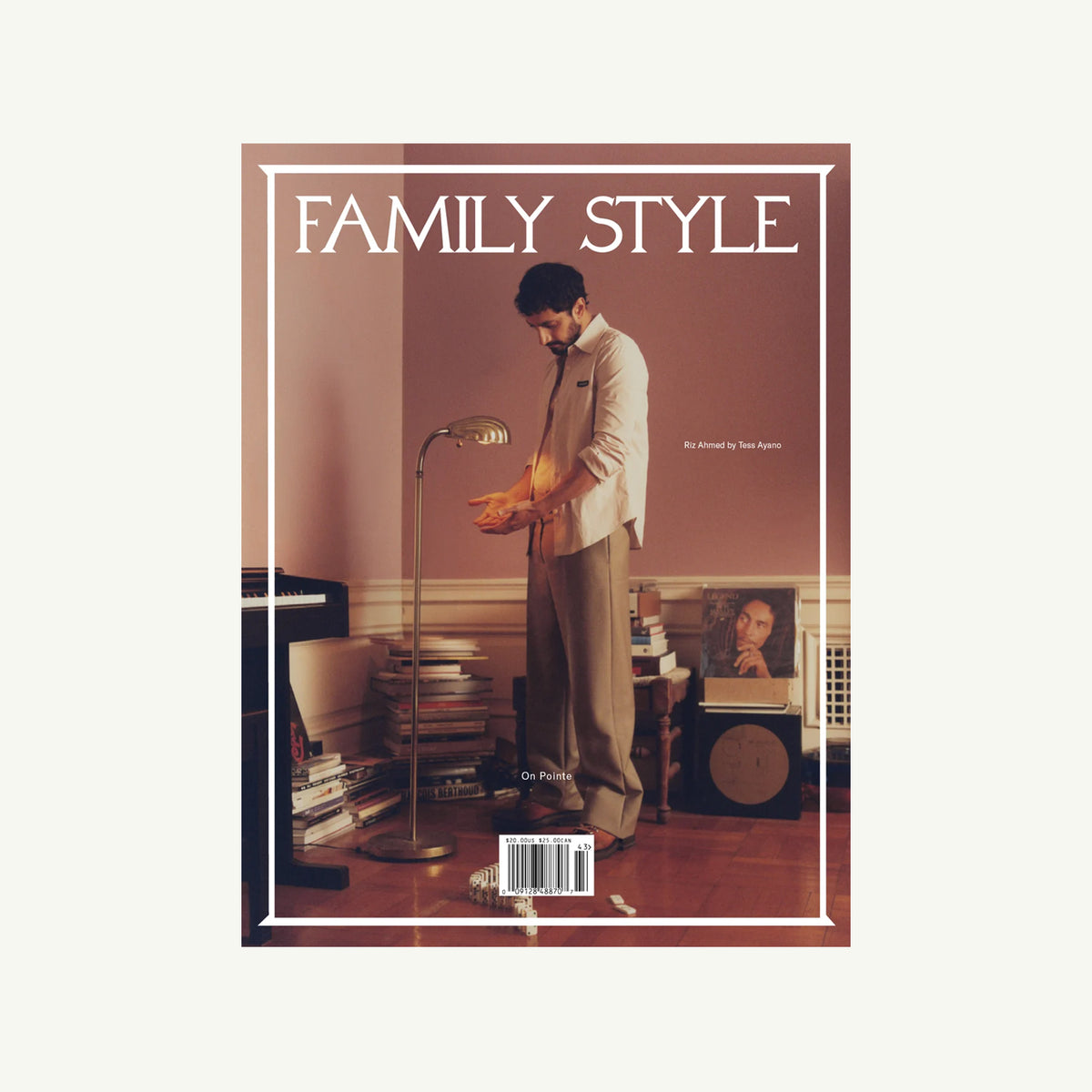 Man in suit by lamp in elegant room on Family Style Magazine cover.