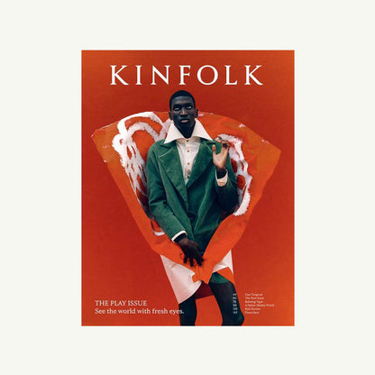 Person in green coat on red Kinfolk Magazine cover by Simon & Schuster; modern, artistic style.