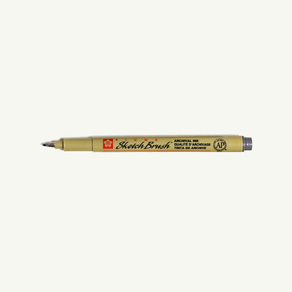 Sakura Pigma Sketch Pen in tan with black tip, shown lying horizontally on a white background.