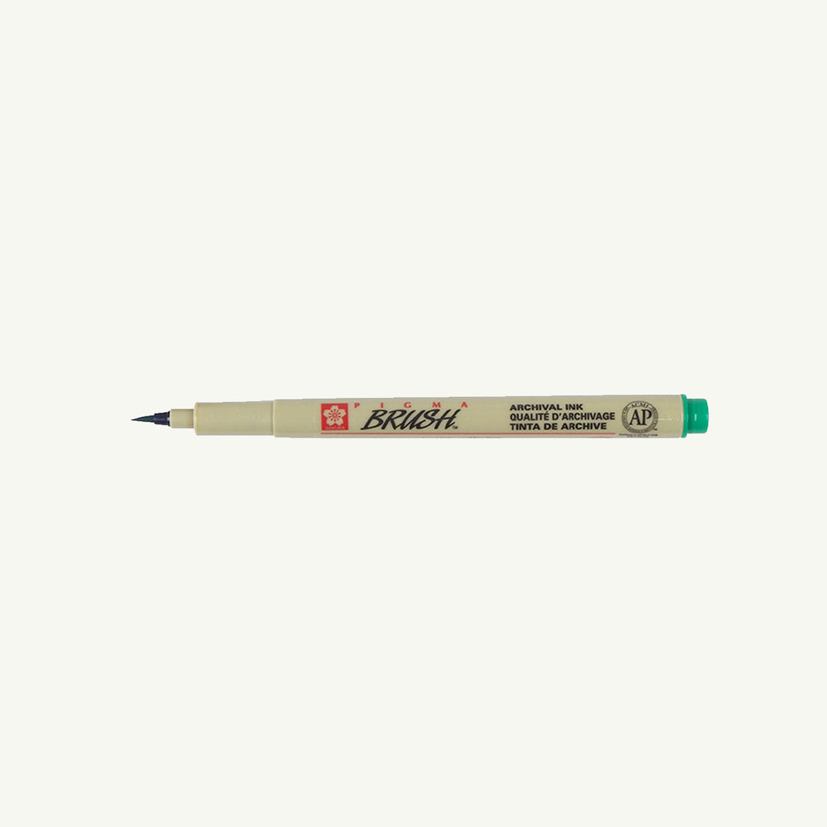 A Sakura Pigma Sketch Pen with a fine green cap tip rests horizontally on a plain background.