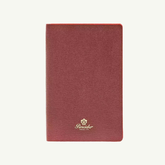 Small Milano Notebook by Pineider 1774 with gold logo and crest, on a white background.