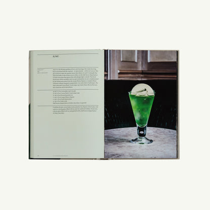 The Connaught Bar by Phaidon open with a green cocktail and round ice sphere on marble table.